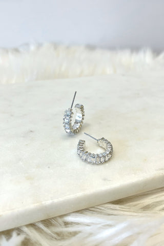 Silver hoop earrings on a marble surface