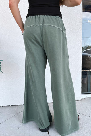 wide-leg, army green, terry sweatpants on a model in front of a building