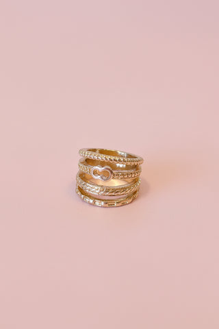 stacked gold ring on a smooth blush colored surface