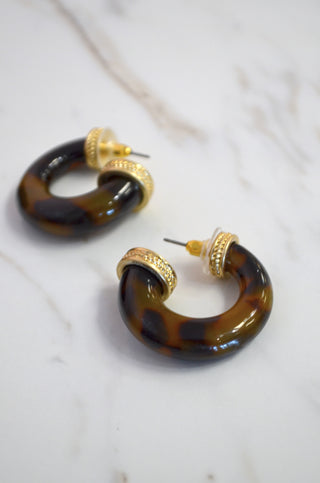  Tortoiseshell hoop earrings with gold accents on a marble surface