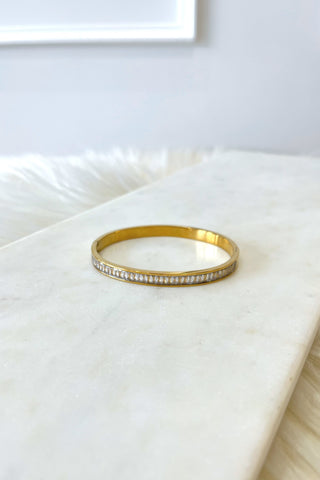 Gold bracelet with crystals on a white surface