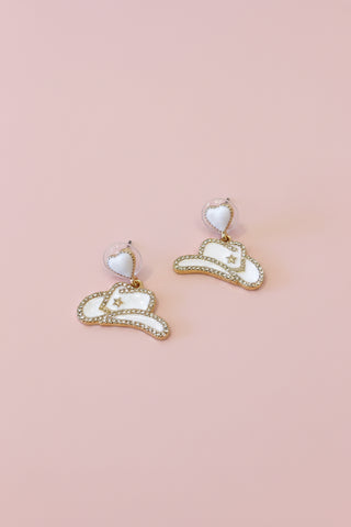 pair of white cowboy hat shaped earrings with a pave design along the outside. 