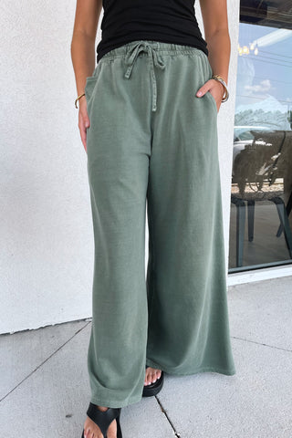 wide-leg, army green, terry sweatpants on a model in front of a building