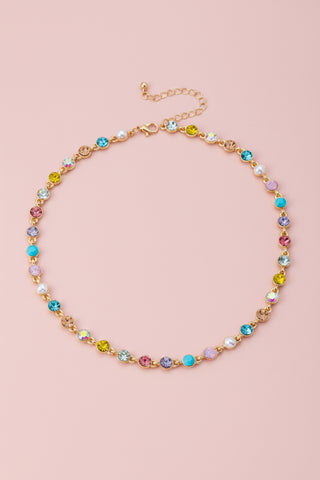 Colorful beaded necklace on a light surface with decorative elements