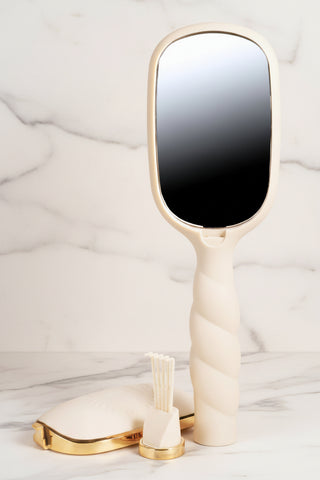 Beige hair brush with a hidden mirror compact on the back.
