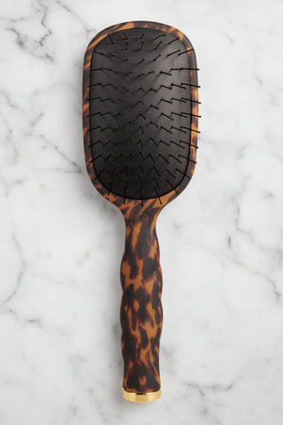 Hairbrush with tortoiseshell pattern on a white background