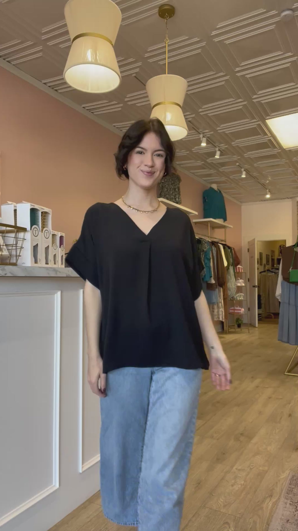 Model wearing an oversized black v-neck top in a size small.