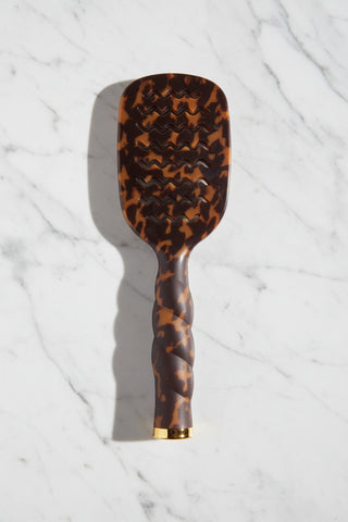 Tortoise Shell print paddle hair brush with wavy line pattern on a white background